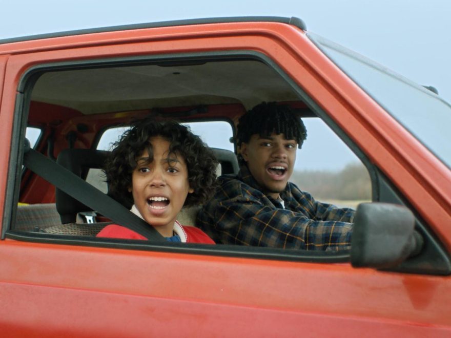 Ein Kind und ein Jugendlicher sitzen in einem Auto.